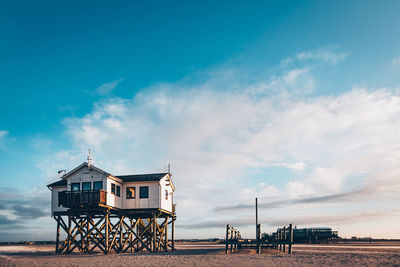 Hut by building against blue sky