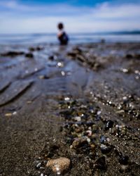 Close-up of pebbles on beach against sky