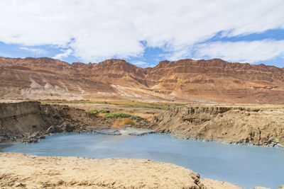 Sinkhole filled with turquoise water, near dead sea coastline. the hole formed when underground salt