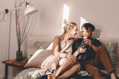 Young woman sitting on sofa at home