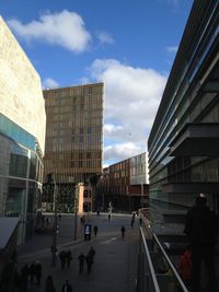 Buildings in city against cloudy sky