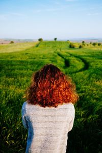 Rear view of woman on field against sky