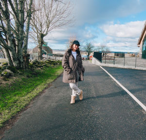 Portrait of man standing on road against sky