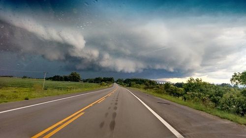 Road passing through landscape during rainy season