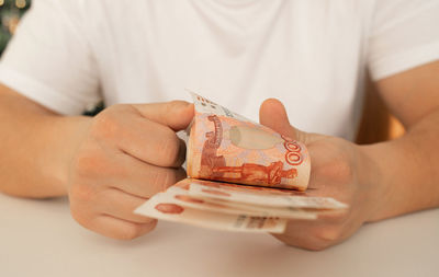 A young man counts money. close-up of the hand with 5000 bills.