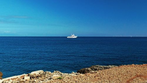 Sailboat sailing in sea against blue sky