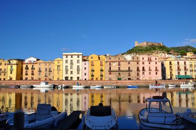 Buildings in city against clear blue sky