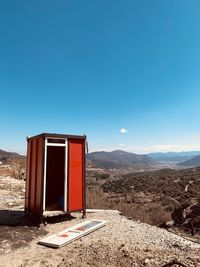 Built structure on landscape against clear blue sky