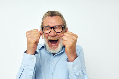 Smiling senior man gesturing against white background