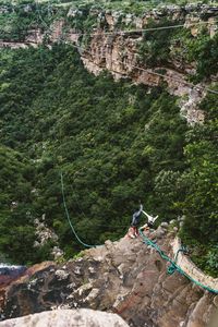 People on rock by tree mountain