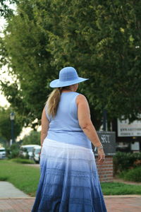 Rear view of woman standing against plants