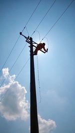 Low angle view of electricity pylon against blue sky