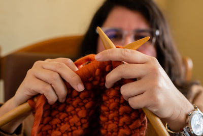 Close-up of woman knitting wool at home