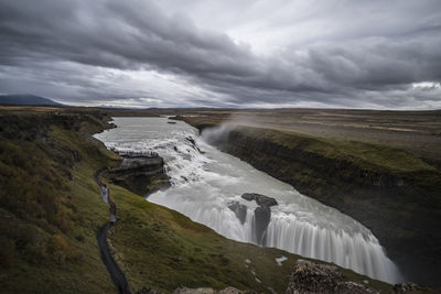 Scenic view of waterfall against sky