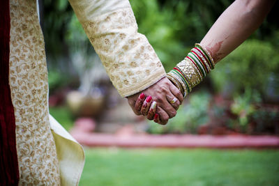 Close-up of bride and groom holding hands