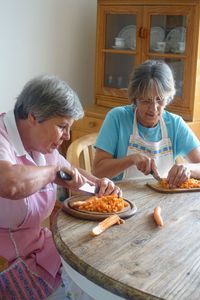 Women chopping vegetables at table