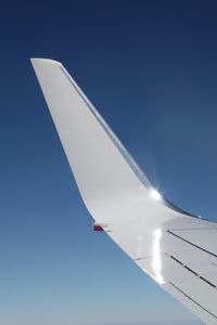 Low angle view of vapor trails against blue sky