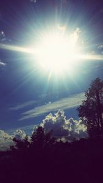 Low angle view of sun shining through silhouette trees