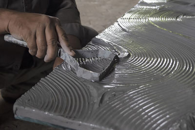 Midsection of man repairing metal