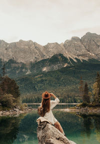 Woman in lake against mountain range