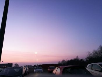 Cars on road against sky during sunset