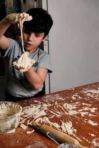 Child preparing pizza dough to make at home