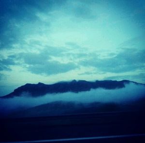 Scenic view of mountains against cloudy sky