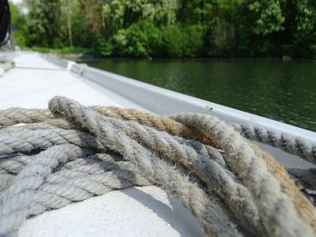 Close-up of rope tied to boat moored at lake