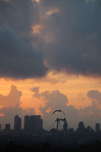 Silhouette buildings against sky during sunset