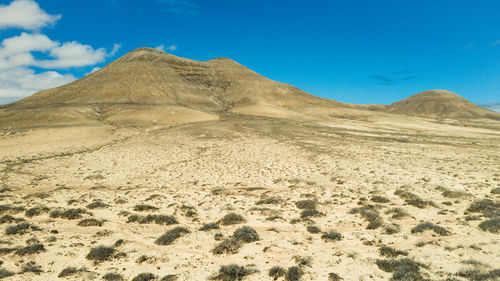 Scenic view of desert against blue sky