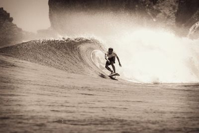 Full length of man surfing on sand