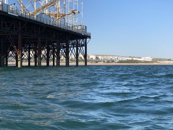 Pier over sea against clear blue sky