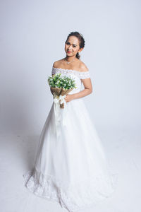 Portrait of smiling woman standing against white background