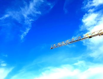 Low angle view of crane against blue sky