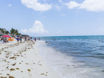 Group of people on beach against sky