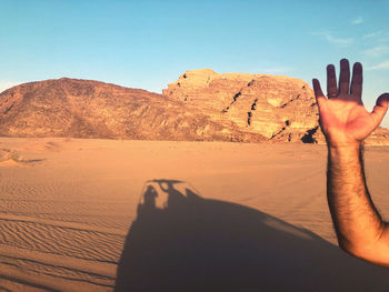 Midsection of person lying on land against sky