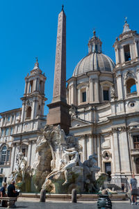 Statue of fountain in city against sky