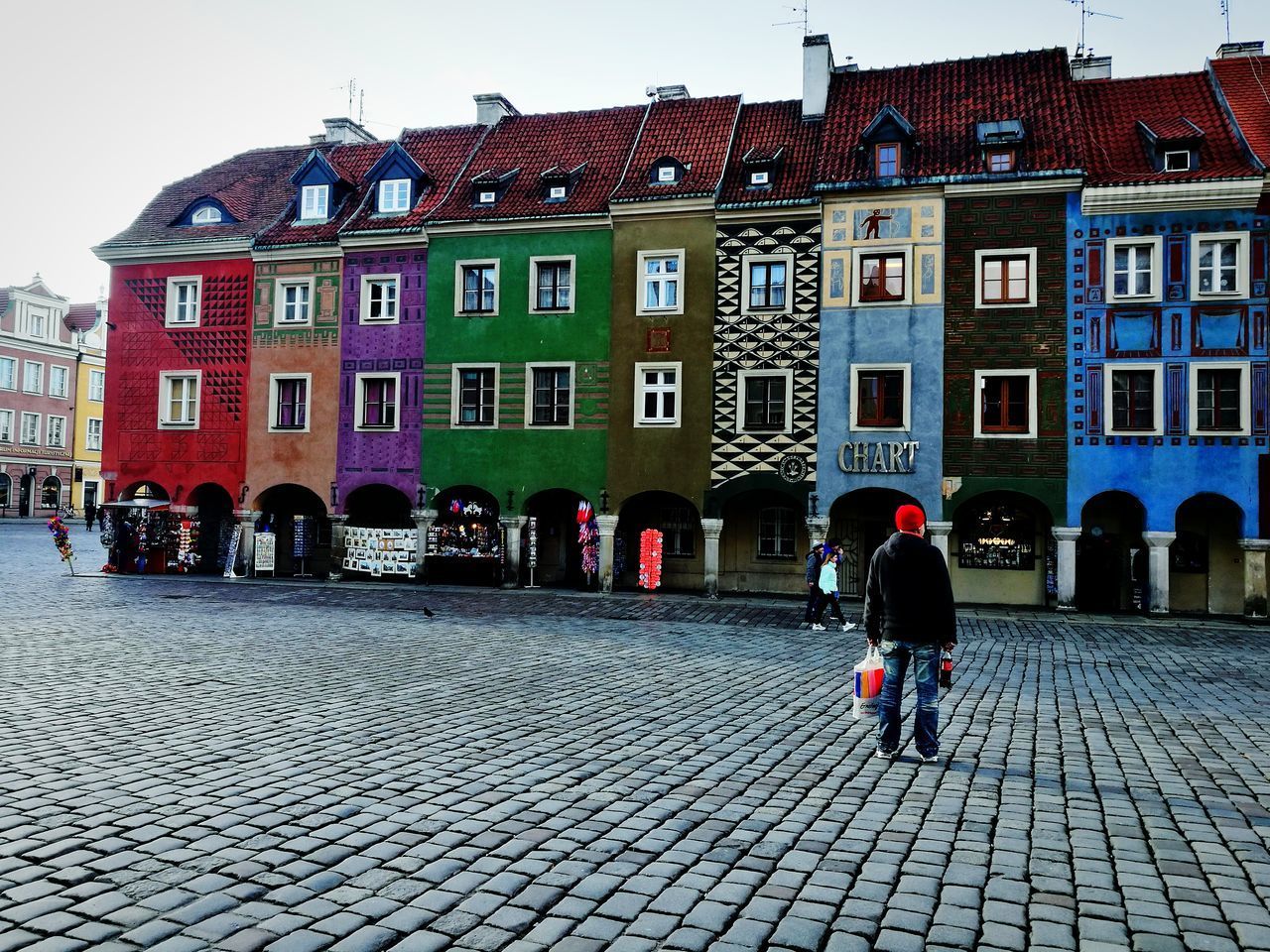 PEOPLE WALKING ON STREET BY BUILDINGS IN CITY