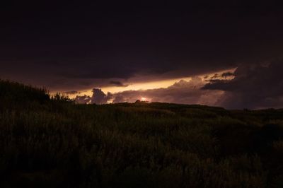 Scenic view of field against sky at sunset