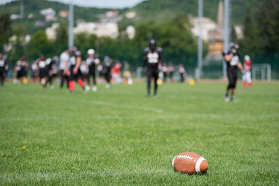 Rugby ball on field with players in background