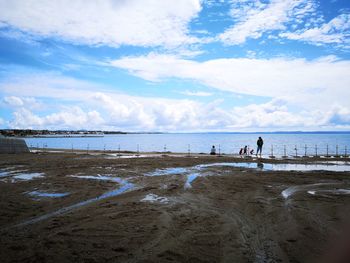 People on beach against sky