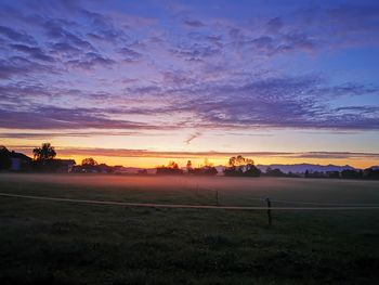 Scenic view of silhouette field against sky during sunset