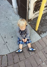 High angle view of boy standing on footpath