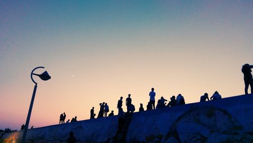 Low angle view of silhouette people against clear sky