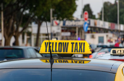 Close-up of yellow taxi sign on car in city