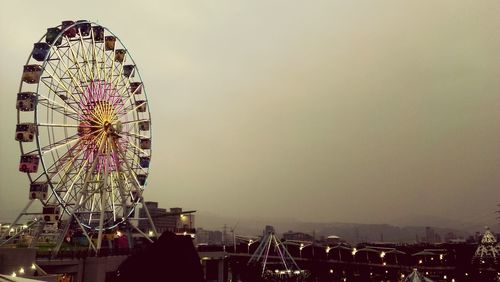 Ferris wheel in city against clear sky