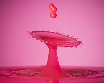 Close-up of red splashing water against gray background
