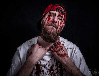 Portrait of man wearing mask against black background