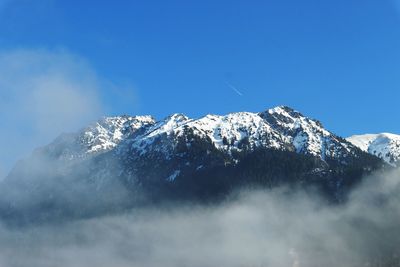 Scenic view of snowcapped mountains against clear blue sky