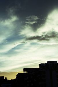 Buildings against cloudy sky